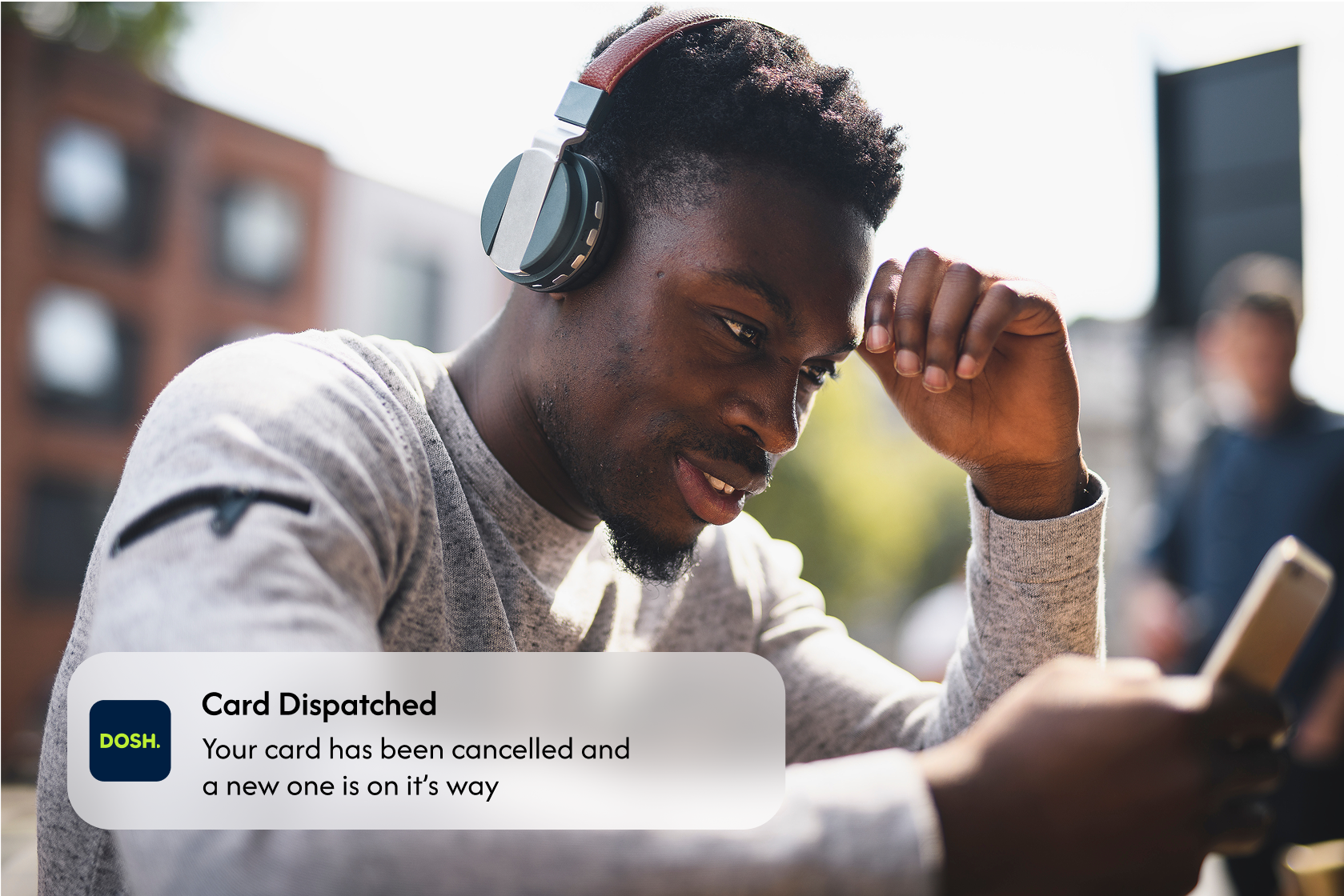 man on phone receiving notification from dosh informing of a new card being dispatched